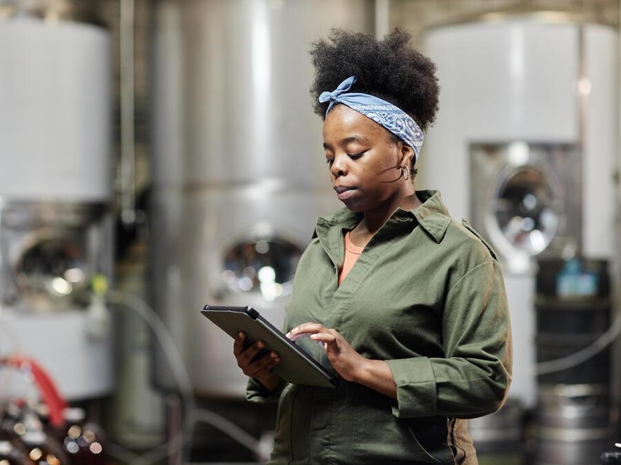 Woman looking at clipboard in brewery