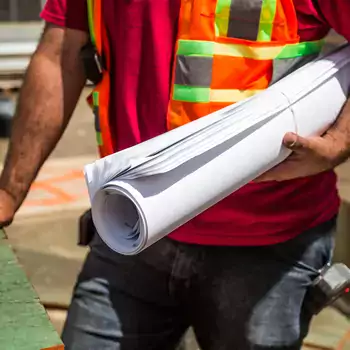 construction worker holding plans on jobsite
