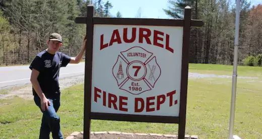 Scott Hensley standing next to the Laurel Fire Dept. sign.