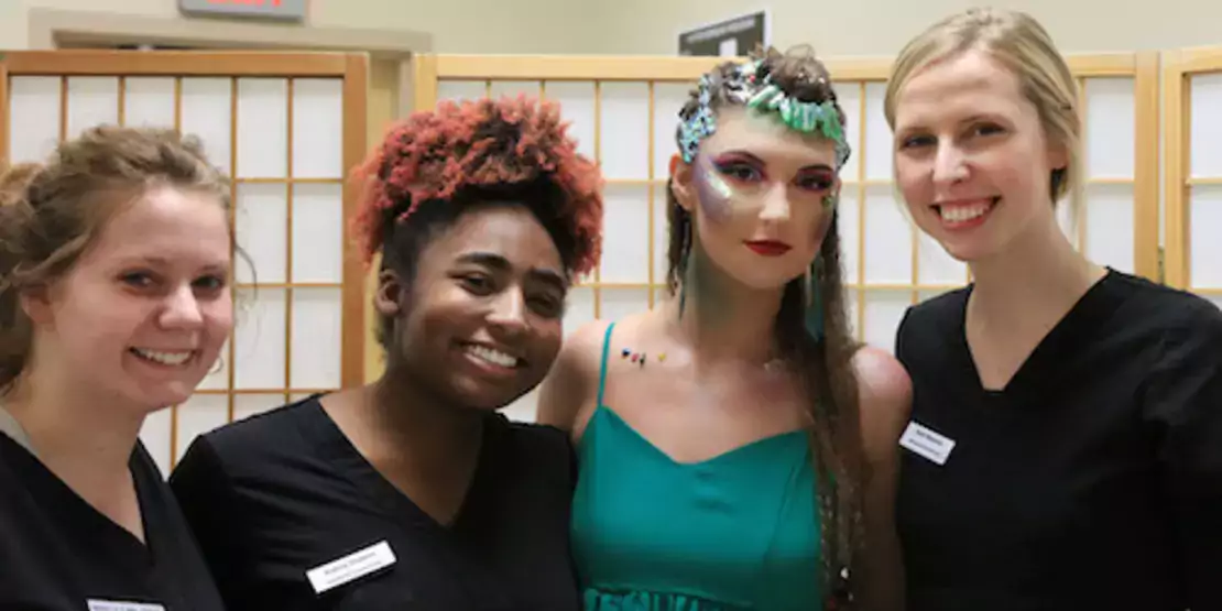 Cosmetology students with a model