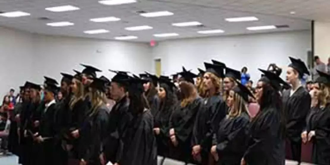 Graduates standing in an auditorium