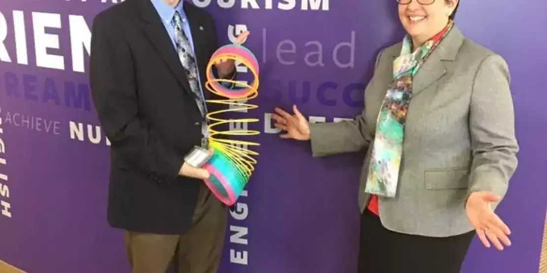 A man and woman standing with a slinky