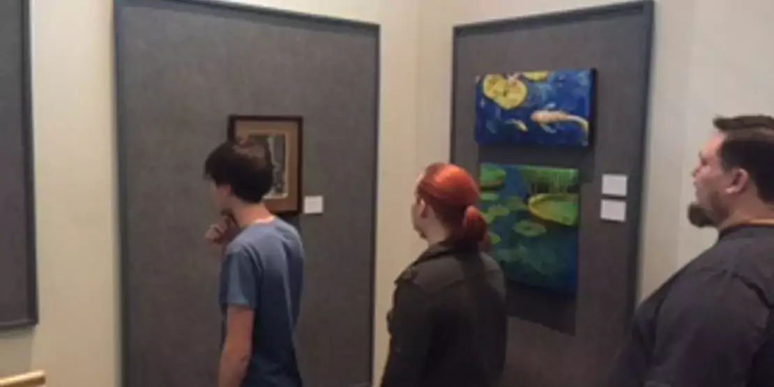 Two students standing in front of artwork