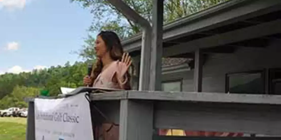 Student Meira Padilla speaking while standing on a deck.
