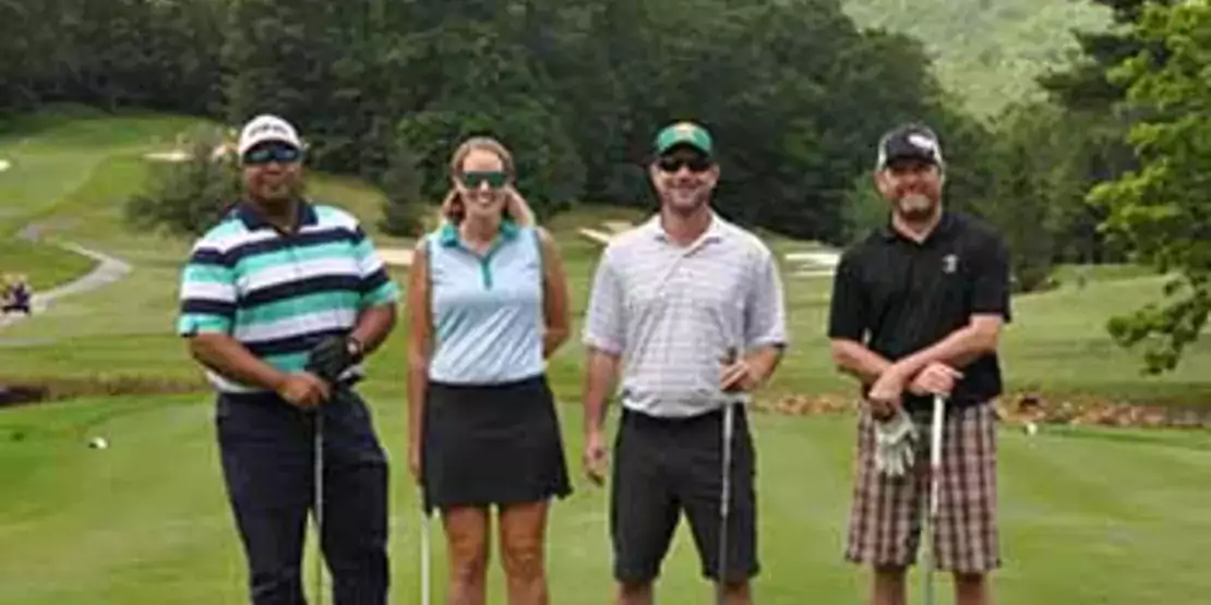 A team of four golfers standing in a tee box
