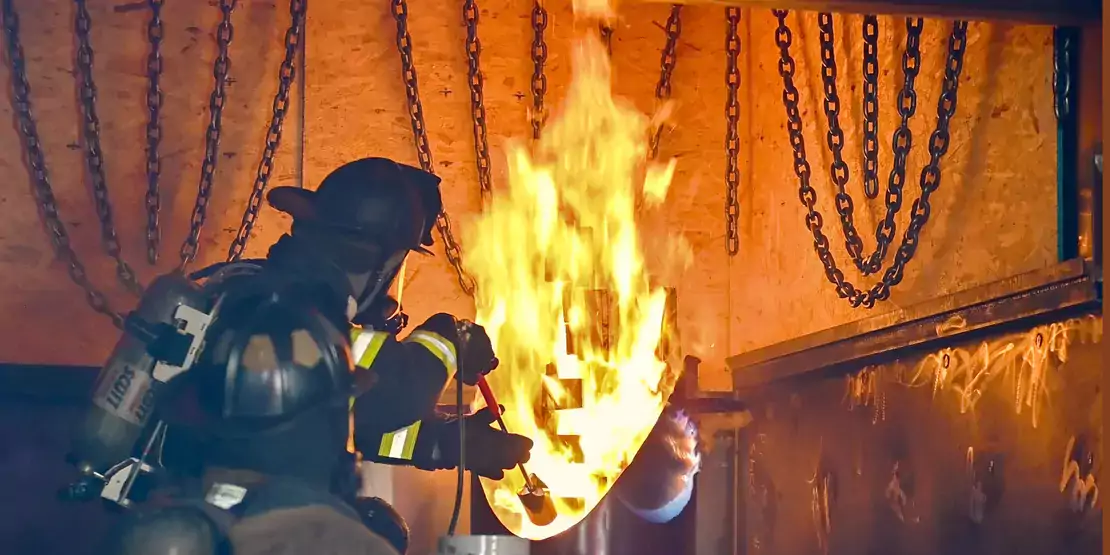 Firefighter student starting a fire in the Fire Simulator during a Flashover Training
