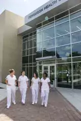 Four nurses walking out of a building